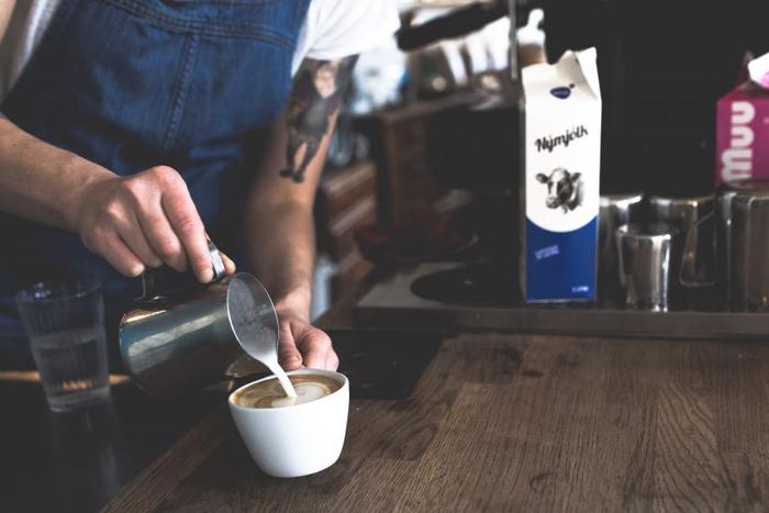 Barista sirviendo un café en la barra