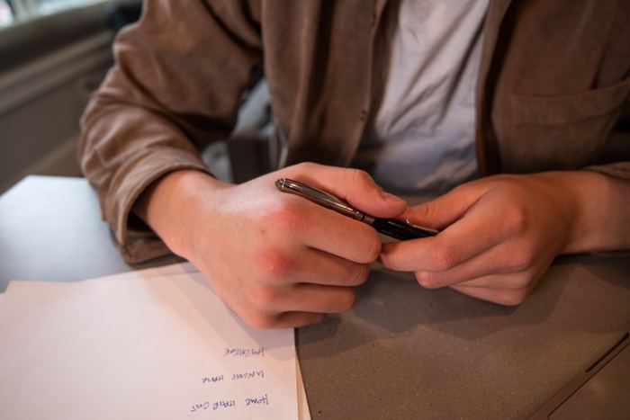 Persona tomando notas sobre papeles de trabajo