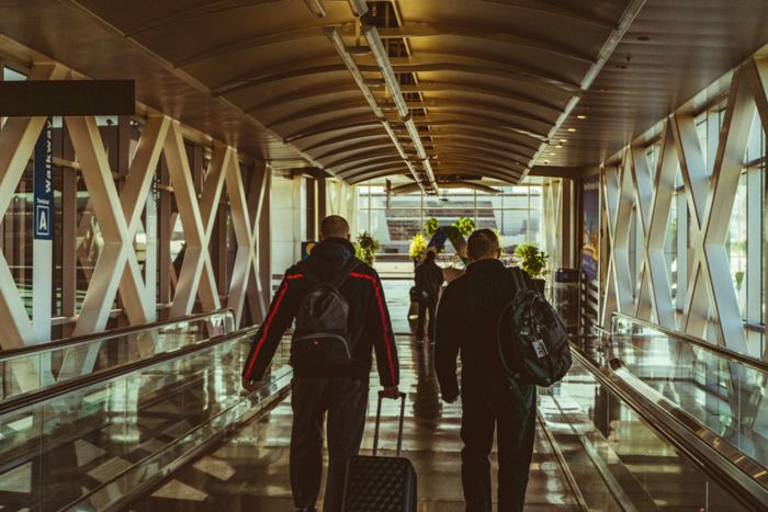 Viajeros caminando por una terminal con sus mochilas